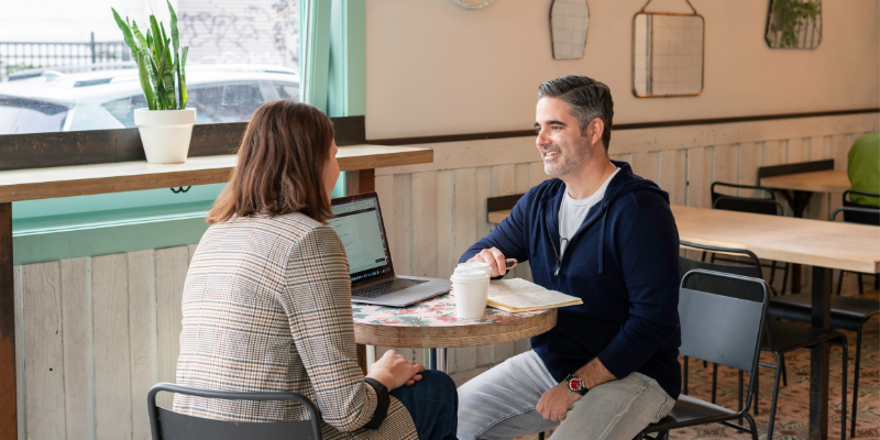A man a woman having a meeting with coffee at a little coffee shop table
